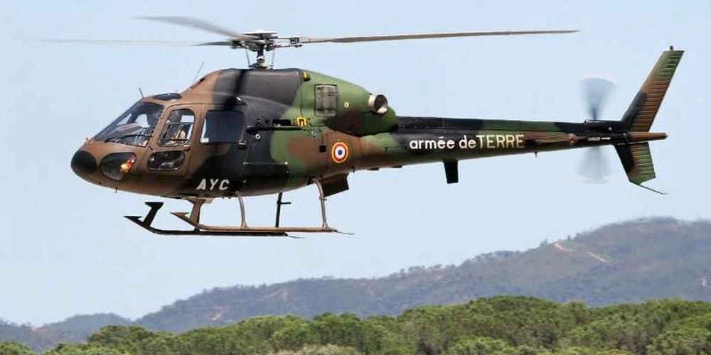 Fennec de l'armée de Terre en vol au-dessus d'un relief boisé